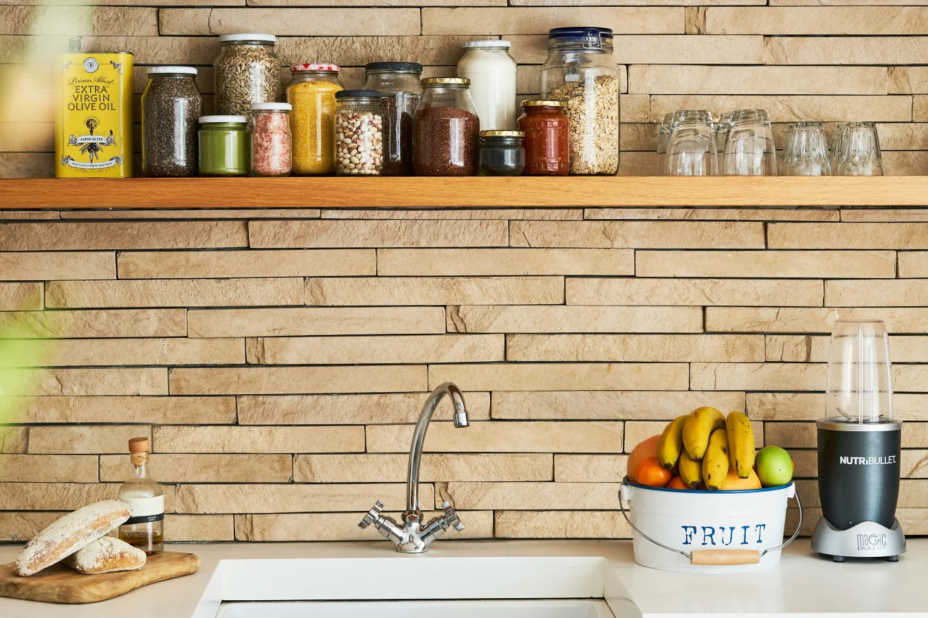 Otwarta półka, ściany z naturalnego kamienia i proste pojemniki - to elementy prowansalskiej kuchni.