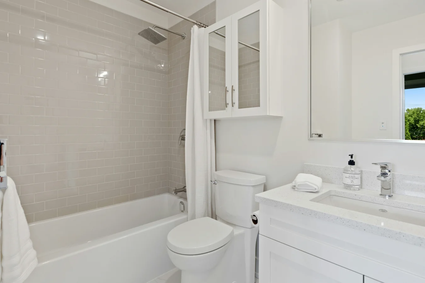 Biały kolor i wanna z prysznicem to pomysł na małą łazienkę.