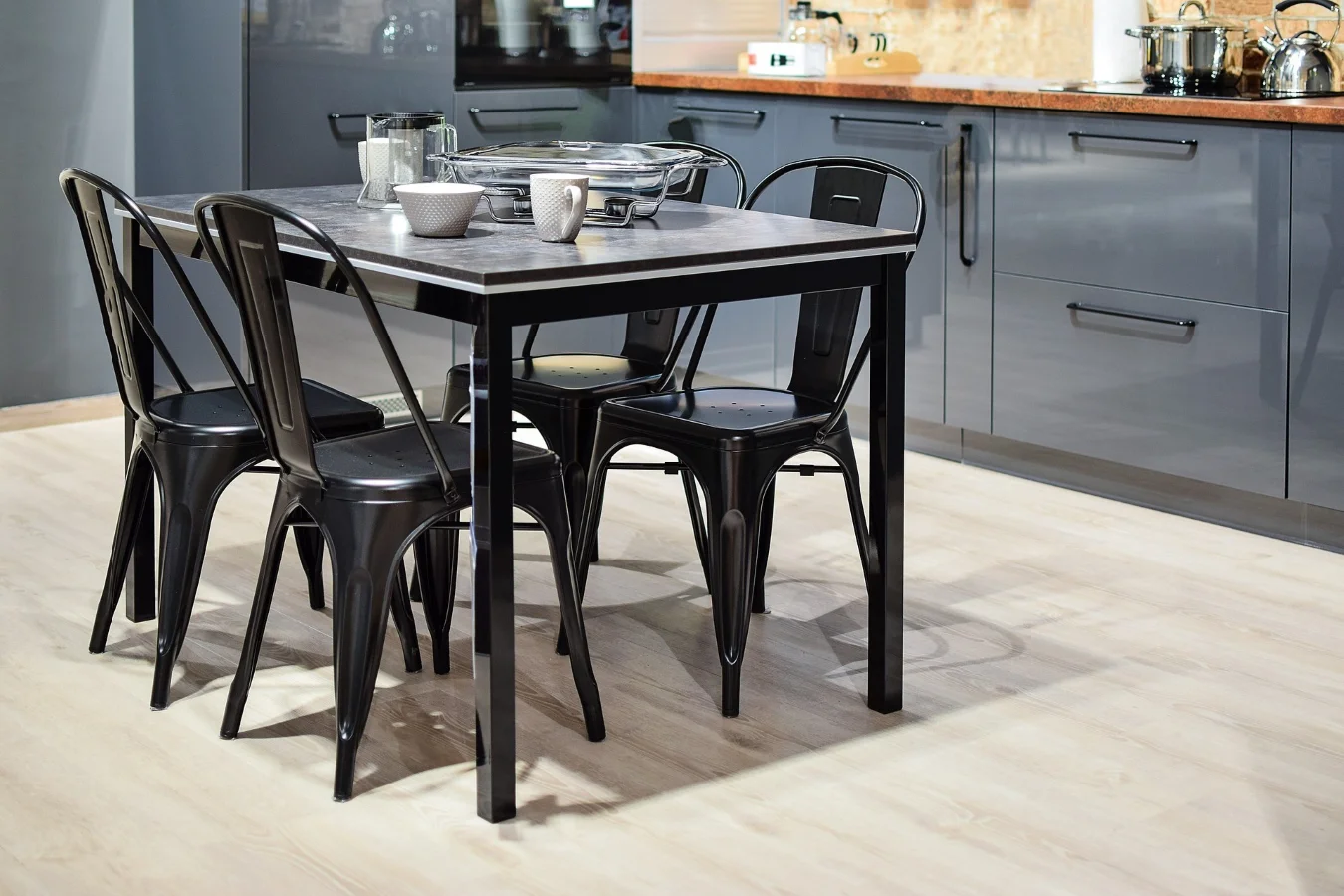 Metalowe czarne krzesła wprowadzają do kuchni nowoczesny akcent.